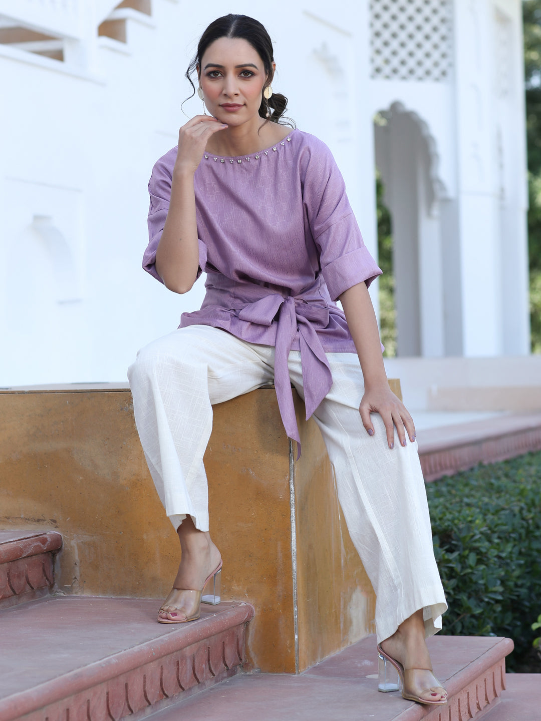 A Mauve Color Self Weaved Embellished Top With Tie-Up At The Waist And Extended Sleeves Top With Cotton White Flared Pants