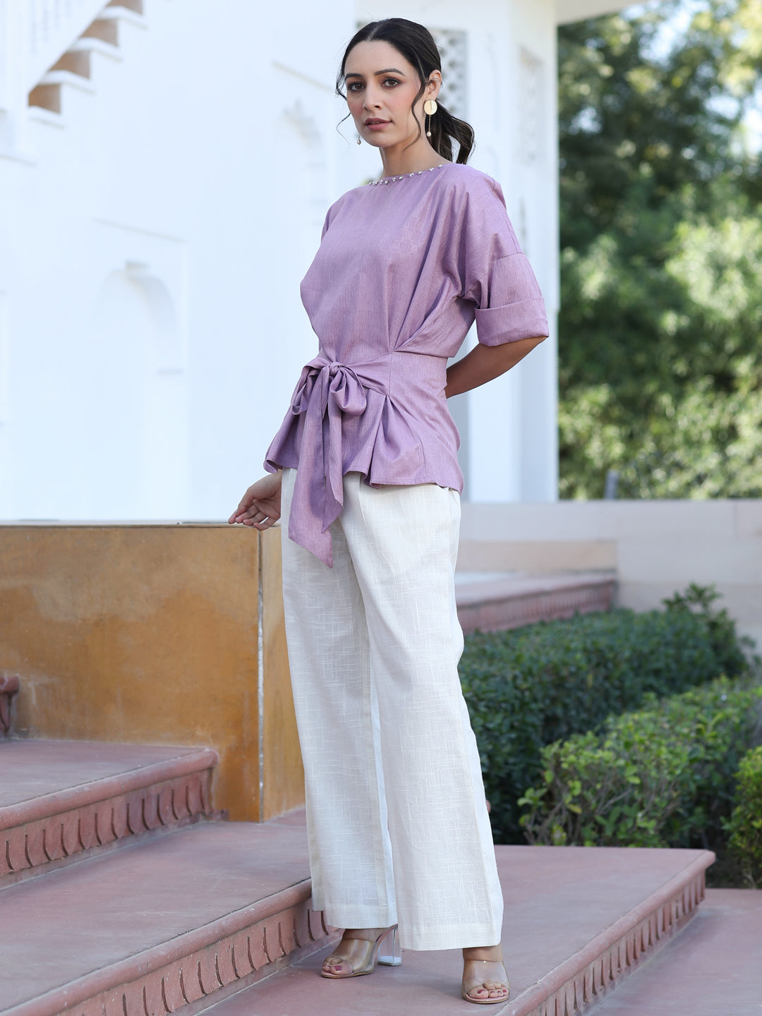 A Mauve Color Self Weaved Embellished Top With Tie-Up At The Waist And Extended Sleeves Top With Cotton White Flared Pants
